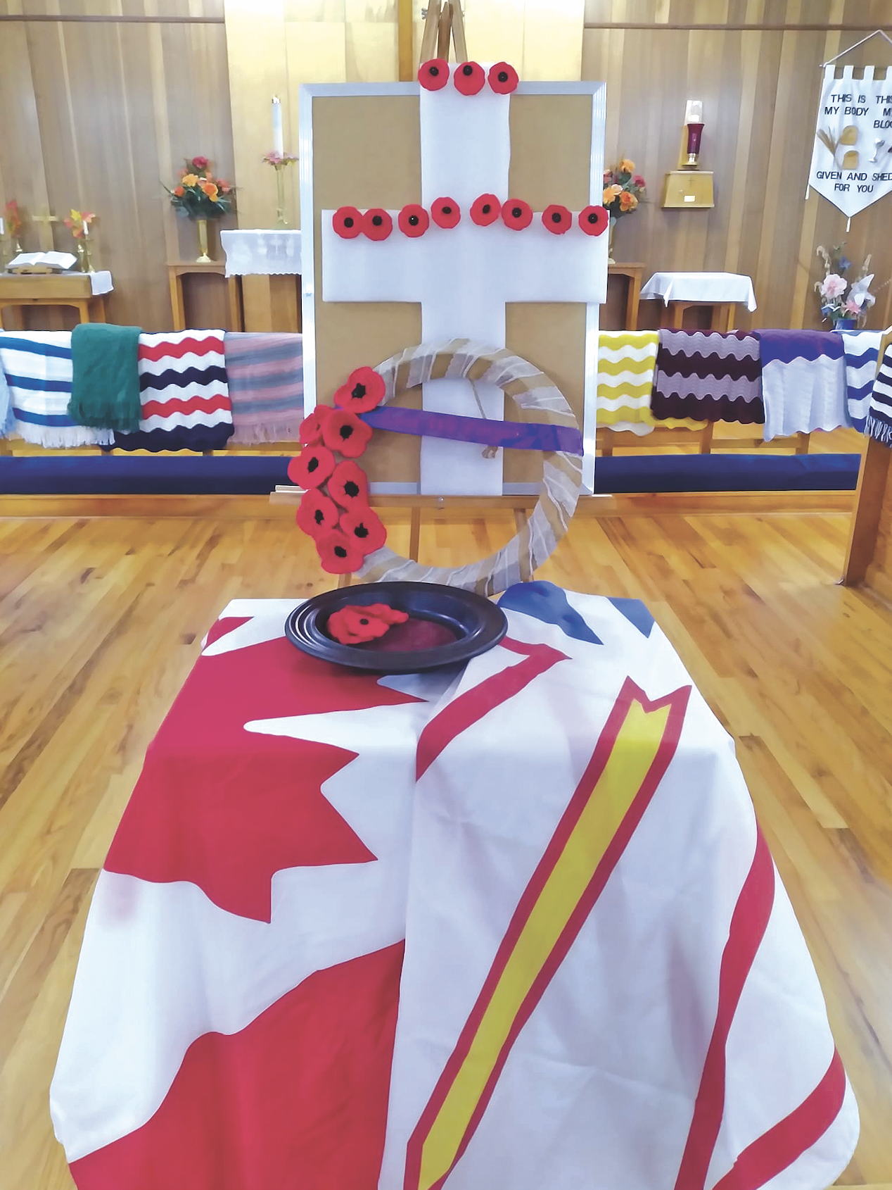 Canadian and Newfoundland flags with a cross for Remembrance Day in a church